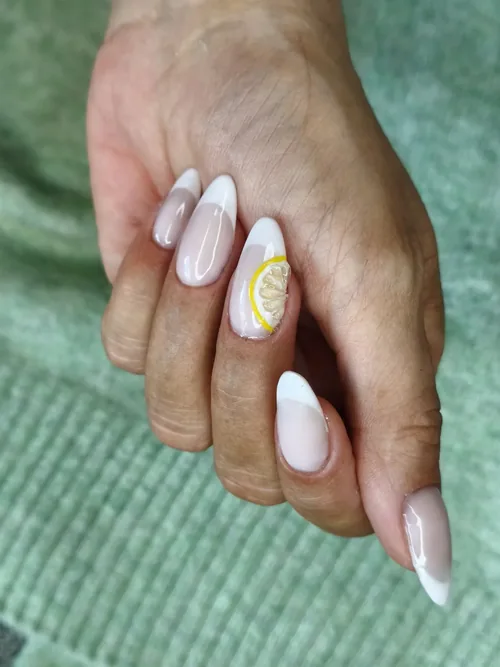 French blanche sur base nude avec un nail art tranche de citron, ongles amande